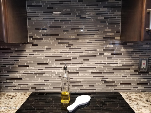 room details with light stone counters and decorative backsplash