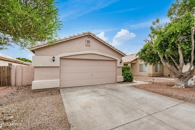 view of front facade featuring stucco siding, driveway, a tiled roof, and an attached garage