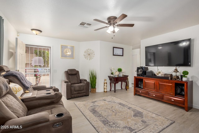 living room featuring baseboards, visible vents, ceiling fan, and light wood-style flooring