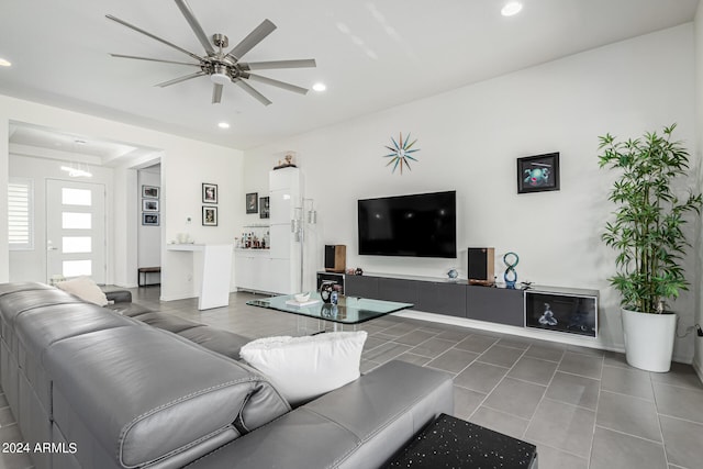 living room with dark tile patterned flooring and ceiling fan