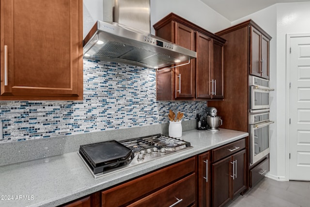 kitchen featuring appliances with stainless steel finishes, tasteful backsplash, and wall chimney range hood