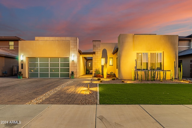 contemporary home featuring a garage and a yard