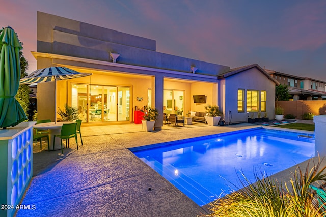 pool at dusk with a patio