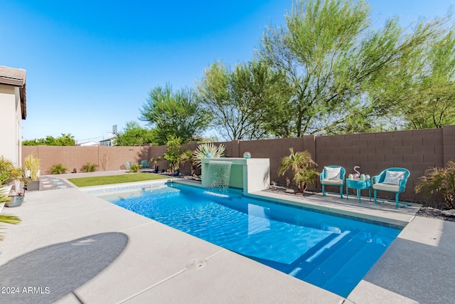 view of swimming pool with pool water feature and a patio area