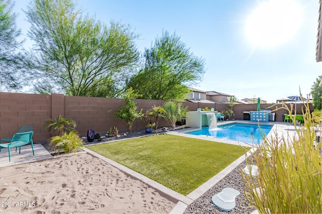 view of swimming pool with a lawn, pool water feature, and a patio