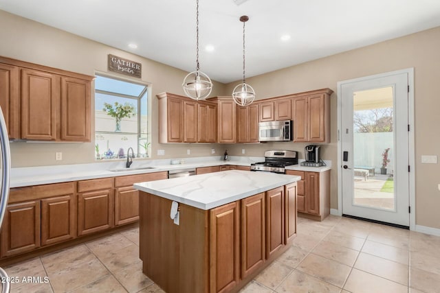 kitchen with appliances with stainless steel finishes, pendant lighting, sink, a center island, and light stone counters