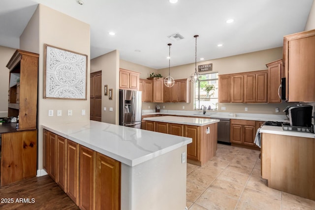 kitchen featuring hanging light fixtures, a center island, kitchen peninsula, stainless steel appliances, and light stone countertops