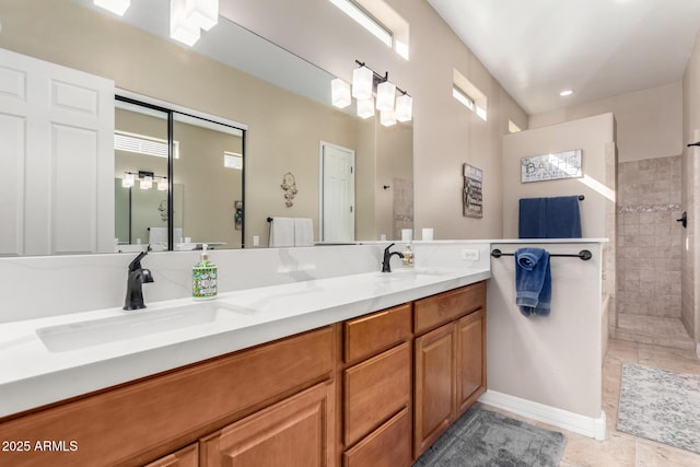 bathroom with tiled shower, vanity, tile patterned flooring, and a wealth of natural light