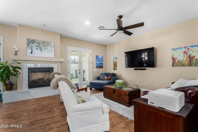 living room with hardwood / wood-style floors, a high end fireplace, french doors, and ceiling fan