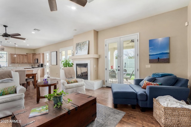 living room with french doors, ceiling fan, plenty of natural light, and light hardwood / wood-style floors