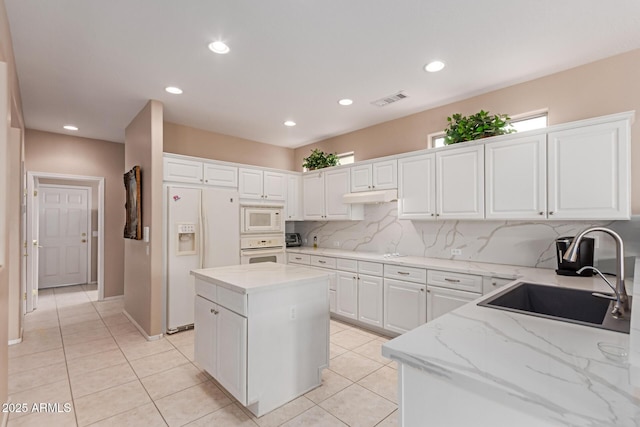 19722 N Regents Park Dr, Surprise, AZ 85387 - kitchen featuring white appliances, a sink, light tile patterned floors, white cabinets, and recessed lighting