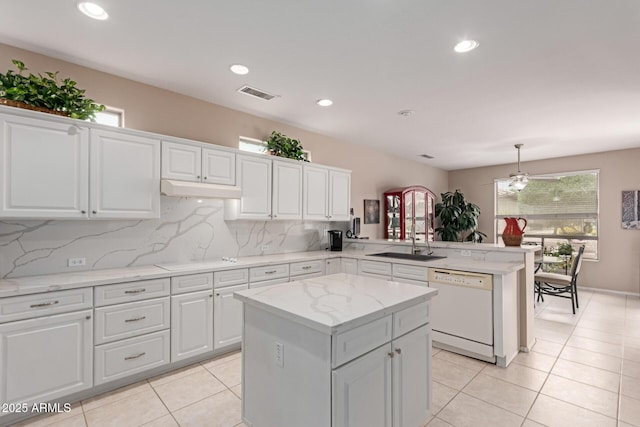 19722 N Regents Park Dr, Surprise, AZ 85387 - kitchen featuring dishwasher, a peninsula, a sink, decorative backsplash, and recessed lighting