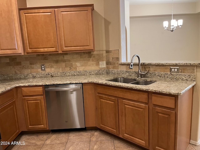 kitchen with light tile patterned floors, stainless steel dishwasher, sink, pendant lighting, and light stone counters