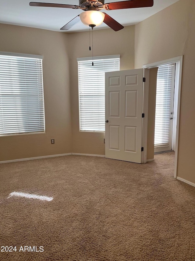 unfurnished room featuring ceiling fan and carpet