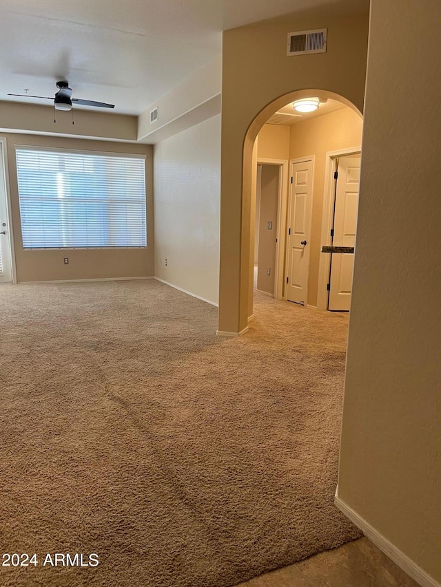 empty room with ceiling fan and carpet flooring