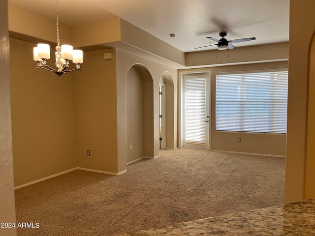 unfurnished room with carpet floors and ceiling fan with notable chandelier