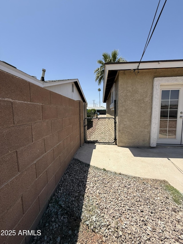 view of property exterior with fence and stucco siding