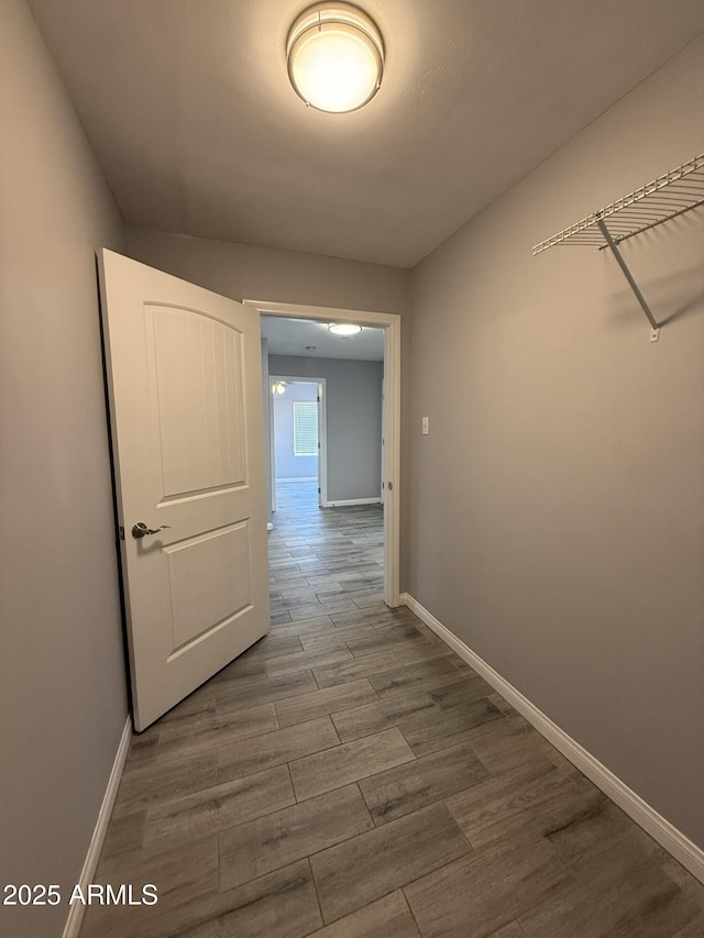 hallway featuring baseboards and dark wood finished floors