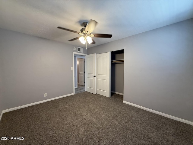 unfurnished bedroom with a closet, visible vents, baseboards, ceiling fan, and dark colored carpet