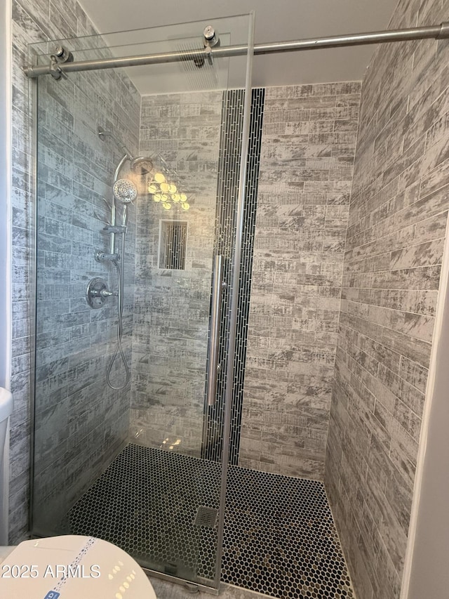 bathroom featuring toilet, visible vents, and a shower stall