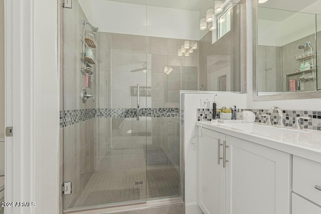 bathroom featuring vanity, an enclosed shower, and tasteful backsplash