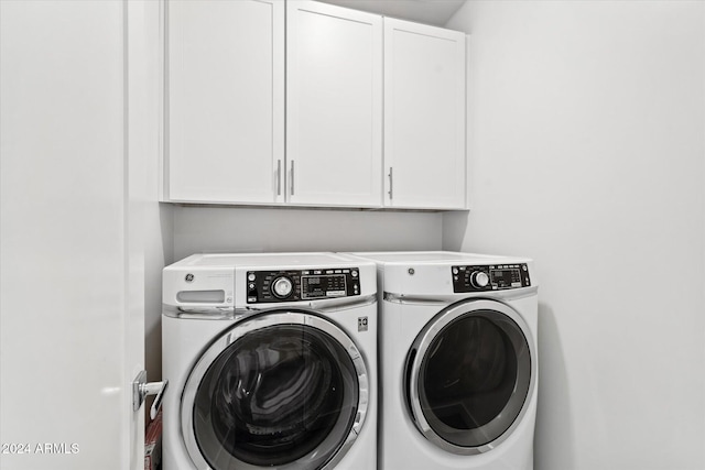 laundry room featuring separate washer and dryer and cabinets