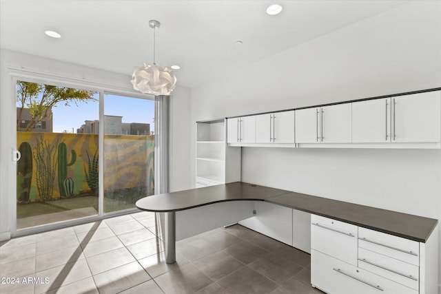 unfurnished office featuring built in desk, light tile patterned floors, and an inviting chandelier