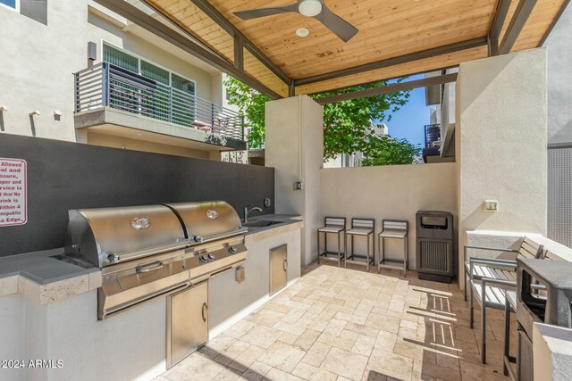 view of patio featuring an outdoor kitchen, ceiling fan, and sink