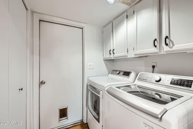 laundry room with separate washer and dryer and cabinets