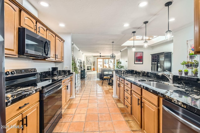 kitchen with pendant lighting, sink, black appliances, and dark stone countertops