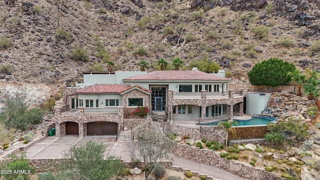 view of front of property with a garage and a balcony