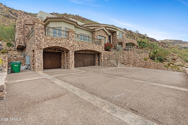 view of front facade featuring a balcony, a garage, and a mountain view