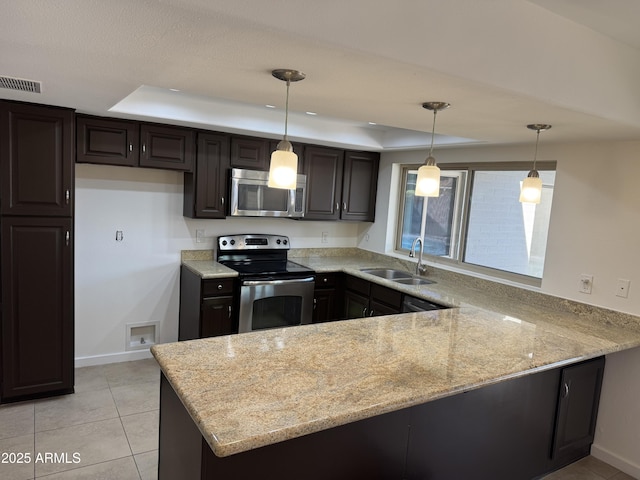 kitchen featuring sink, decorative light fixtures, appliances with stainless steel finishes, kitchen peninsula, and a raised ceiling