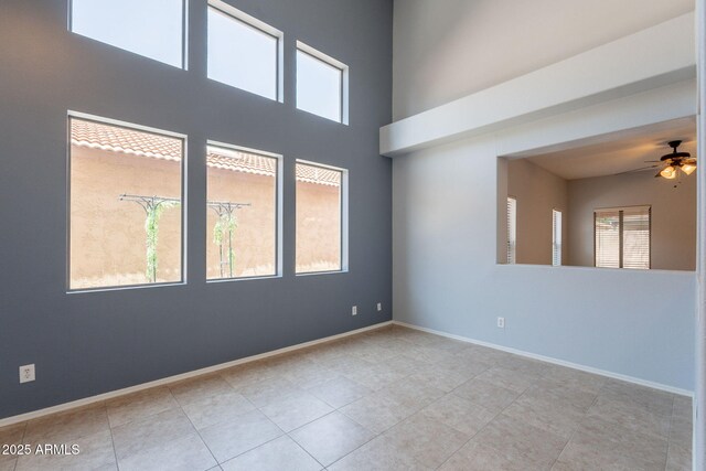 931 S Racine Ln, Gilbert, AZ 85296 - tiled empty room featuring plenty of natural light, ceiling fan, and a high ceiling