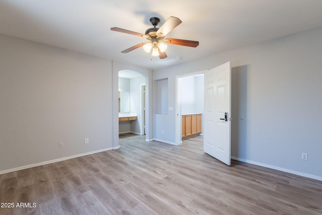 931 S Racine Ln, Gilbert, AZ 85296 - spare room with arched walkways, a ceiling fan, and light wood-style flooring