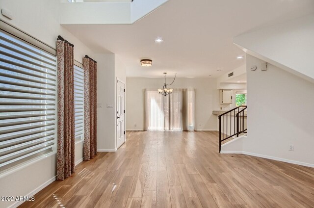 interior space with a notable chandelier and light hardwood / wood-style flooring