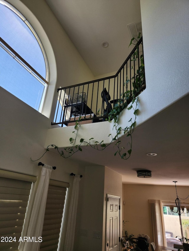 staircase featuring a notable chandelier and a towering ceiling