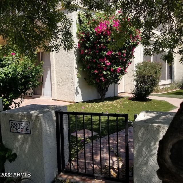 view of gate with a lawn