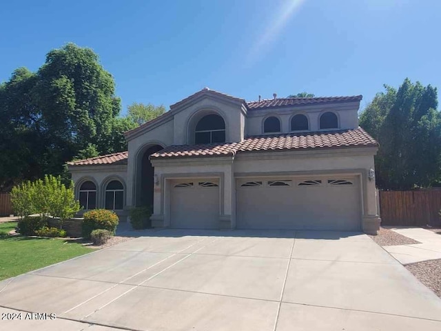 mediterranean / spanish-style home with a garage