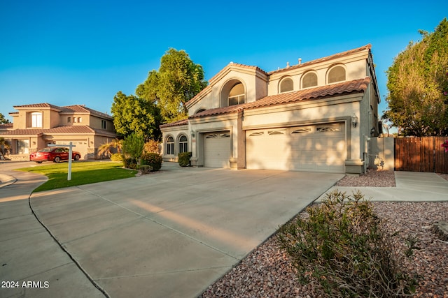 mediterranean / spanish-style house with a garage and a front lawn