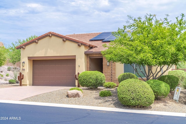 view of front of home with a garage and solar panels