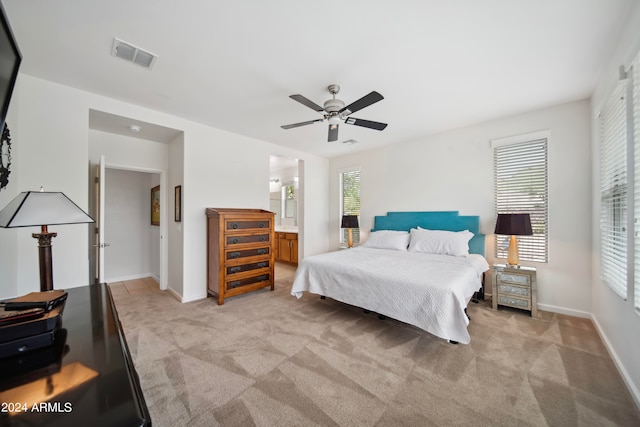 carpeted bedroom featuring ensuite bath and ceiling fan