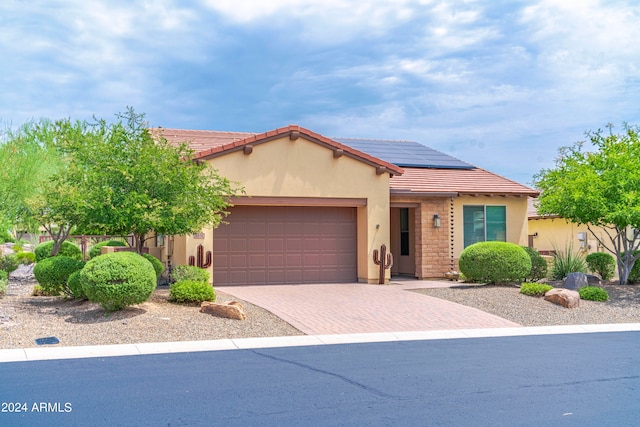 view of front of home featuring a garage and solar panels