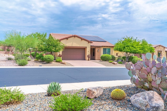 view of front of property featuring a garage and solar panels