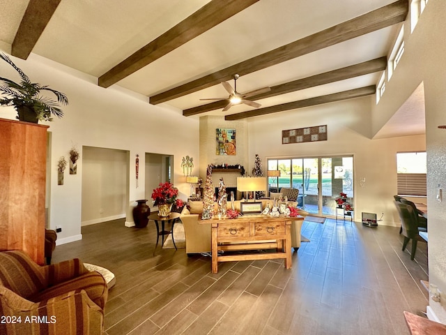 living room with a high ceiling, ceiling fan, and beam ceiling