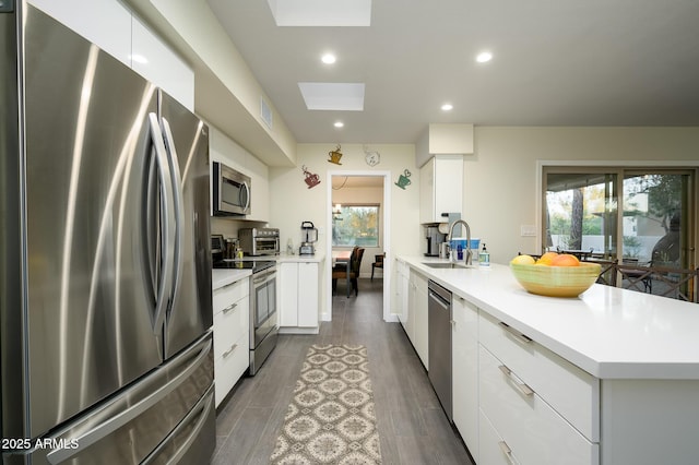 kitchen featuring white cabinets, a healthy amount of sunlight, sink, and stainless steel appliances