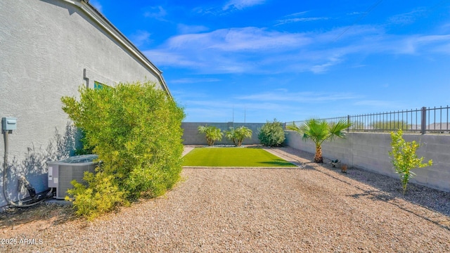 view of yard with central AC unit and a fenced backyard