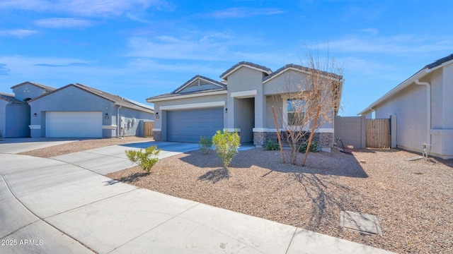 view of front of property featuring an attached garage, fence, driveway, stone siding, and stucco siding