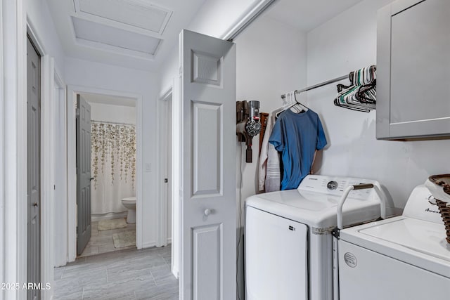 washroom with washer and dryer and cabinets