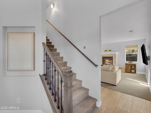 2395 S Polaris Way, Flagstaff, AZ 86001 - staircase featuring a glass covered fireplace, baseboards, and carpet flooring